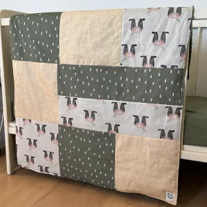 Prête à partir, Couverture de style courtepointe légèrement matelassée, vaches noires et blanches. Endos doux en minky vert olive